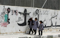 أطفال أمام غرافيتي في مدينة الخليل