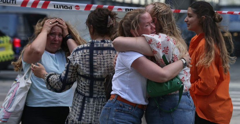 People embrace as police evacuate of the Fields shopping center in Copenhagen