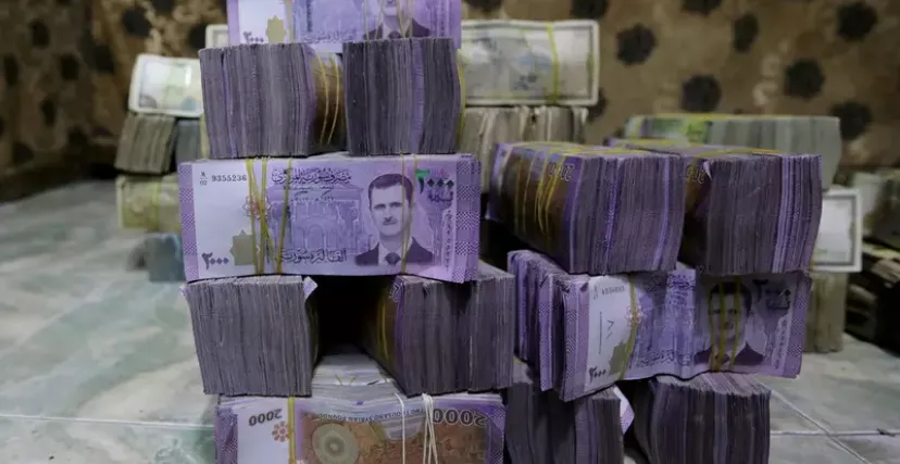يستمر تراجع قيمة الليرة السورية بسبب سياسات النظام (رويترز)