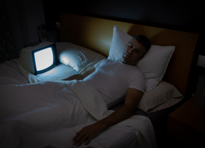 a man sleeping next to a screen